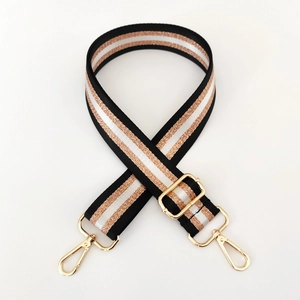 Detail of adjustable nylon strap with gold metallic stripes and spinning lobster clasps