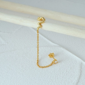 Close-up of gold S925 sterling silver snake chain earring with white rhinestones