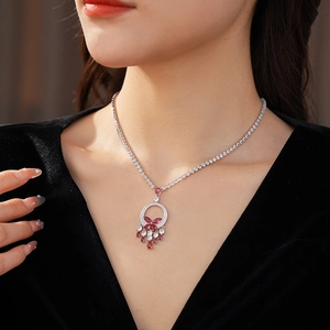 Detail of silver clover necklace with pink and clear crystals worn by a model