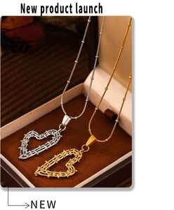 Detail of woven heart pendants in gold and silver finish on velvet display tray