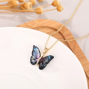 Close-up of a butterfly pendant with purple starry textures and sparkling golden details