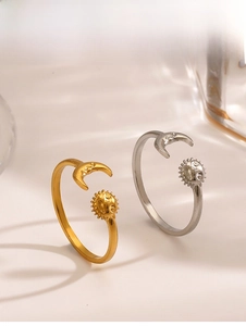 Macro detail of sun and moon open rings in gold and silver finish on light background