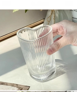 Close-up of heart-shaped glass cup with vertical ribbed texture and high transparency