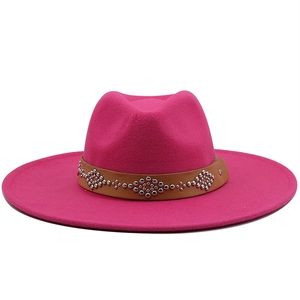 Close-up of rose red wool fedora with brown leather rivet band and geometric pattern