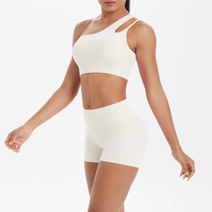 Detail of one-shoulder cream yoga sports bra and high-waist shorts set fabric