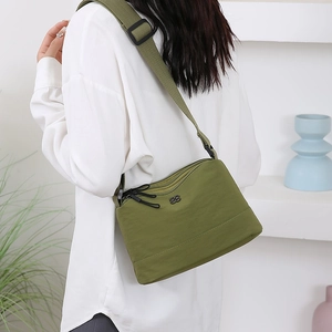 Sac bandoulière en nylon vert avec sangle réglable et plusieurs poches zippées