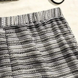 Detailed macro view of the striped knit mesh fabric and elastic waistband on the bikini skirt