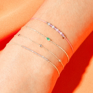 Detail showing S925 silver bracelets layered with green zircon and purple beads