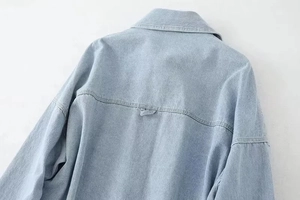 Detail of light blue denim jacket collar and shoulder stitching with premium texture