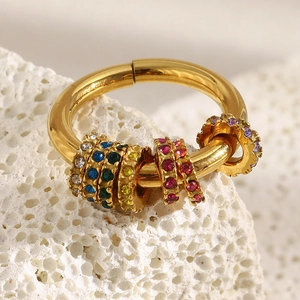 Bague en acier inoxydable plaqué or 18K avec zircons colorés sur fond de pierre