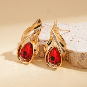 Close-up of teardrop-shaped red gemstone earrings with gold-plated alloy settings