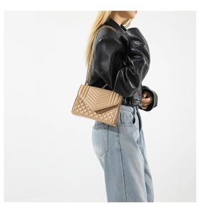 Detail of khaki quilted crossbody bag with gold chain strap and V-shaped stitching
