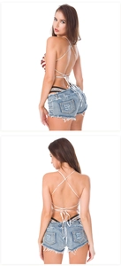 Vista posteriore del top bianco con lacci e pantaloncini di jeans chiari strappati