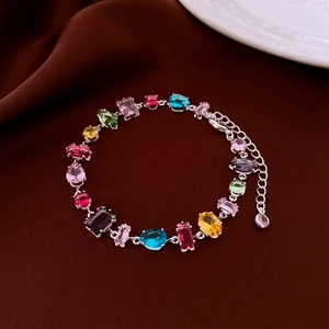 Nahaufnahme von Silberarmband mit bunten Zirkonia in Quadrat- und Tropfenform
