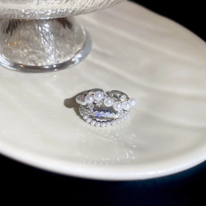 Macro detail of 18k gold plated open ring featuring tiered pearls and sparkling zircon stones