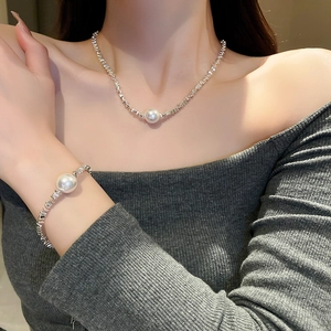 Silver necklace and bracelet set with irregular links and white pearl on a model