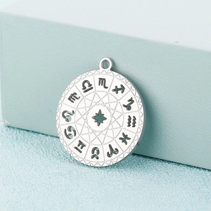 Macro shot of silver zodiac pendant with etched celestial symbols and star design