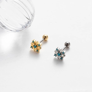 Detail of gold and silver screw-back cartilage studs with turquoise stones
