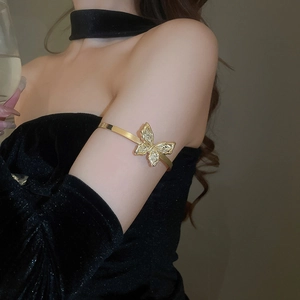 Detailed view of elegant gold butterfly arm cuff with sparkling crystals on model