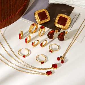 Flat lay of vintage gold jewelry set featuring red zircon stones and cherry pendants