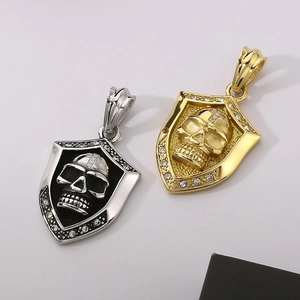 Detail of silver and gold skull shield pendants with rhinestone inlay and punk style