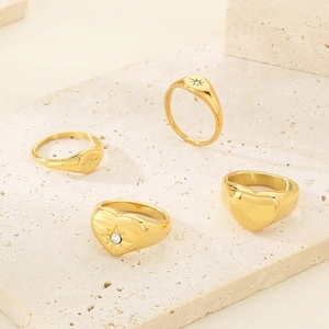 Detailed close-up of 18K gold plated signet rings with heart and star patterns on stone