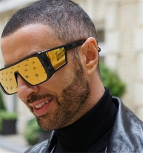 Side view of model wearing black frame shield sunglasses with yellow mirrored lenses