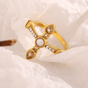 Detail of 18K gold-plated stainless steel cross ring with central pearl and crystals