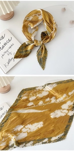 Detail showing the pleated texture and yellow floral pattern of the decorative neck scarf