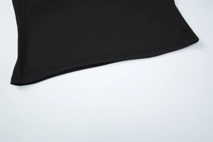 Detailed close-up of black top hemline showing high-quality double-needle stitching and fabric