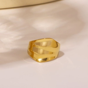 Minimalist wide concave wave ring in golden stainless steel on a warm neutral surface