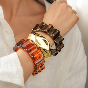 Three-piece acrylic and gold metal bangle set with marble and tortoiseshell patterns