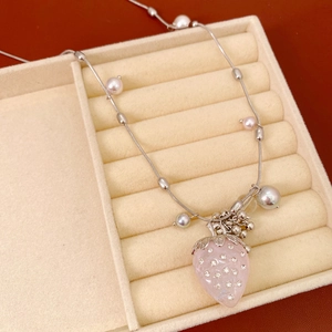 Detailed view of pink strawberry pendant necklace with pearls and rhinestones