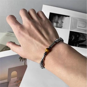 Dettaglio del bracciale con occhio di tigre e perle d'argento in stile vintage