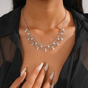 Élégant collier à pampilles argenté avec strass et perles blanches sur mannequin