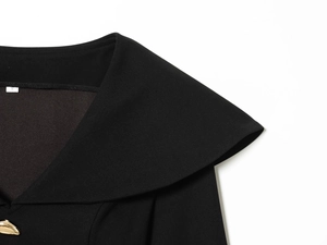 Macro detail of V-neck lapel with modern gold buckle and S size tag on black suit jacket