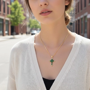 Model wearing a 18K gold plated cross necklace with green zircon and white crystals