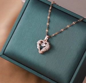 Macro shot of rose gold heart pendant with crystals in a dark green jewelry box