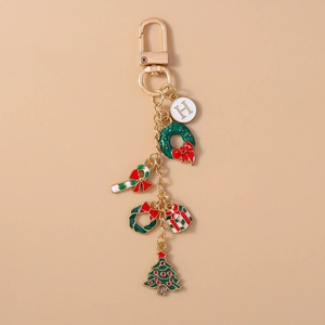 Macro detail of Christmas keychain with gold H letter, wreath, and candy cane charms