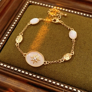 Close-up of gold starburst bracelet with oval stone on green velvet and wood