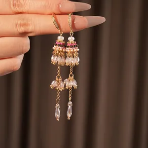 Bohemian tassel earrings with pearls and colorful beads shown on a rich velvet backdrop