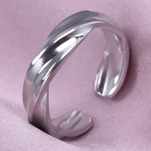 Detailed close-up of a silver irregular wavy ring on soft pink silk background