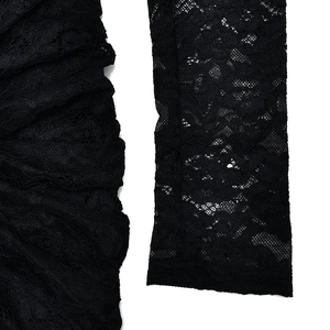 Detailed close-up of the black lace fabric with floral patterns and pleated cuff details