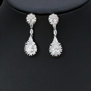 Close-up of silver drop earrings with clear faceted crystals on a black mannequin