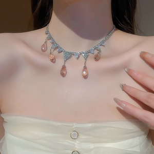 Close-up of elegant water drop tassel necklace with champagne pink zircons on a model