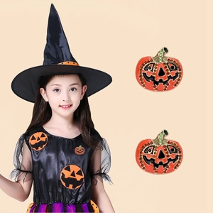 Detail of Halloween pumpkin brooches with orange rhinestones on a beige garment