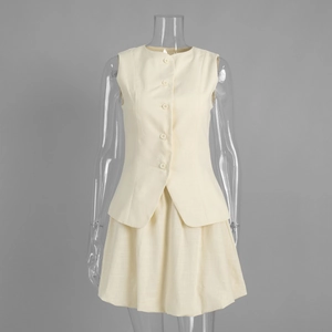 Détail d'un ensemble beige gilet et jupe montrant la texture du lin et les boutons