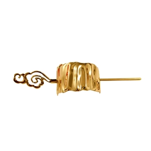 Close-up of golden metal hair clip featuring intricate moiré patterns and textured finish