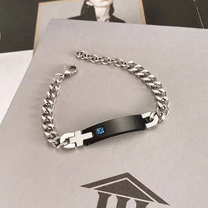 Polished silver chain bracelet with black cross plaque and blue gemstone inlay detail
