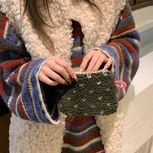 Close-up of plush dark green polka dot storage bag with soft lamb wool texture